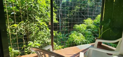 a screened in porch with two chairs and a window at El Retiro Del Bosque-Natural mystery in Manuel Antonio
