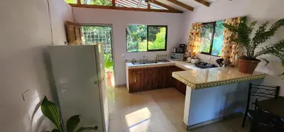 a kitchen with a white refrigerator and a sink at El Retiro Del Bosque-Natural mystery in Manuel Antonio