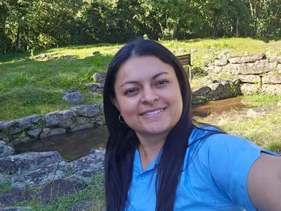 a woman with long black hair smiles at the camera at Casa Roncha Hospedaje in Turrialba