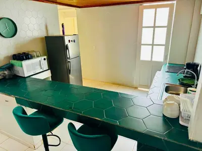 a kitchen with a green counter top and a refrigerator at Casa Pura Vida in Puntarenas