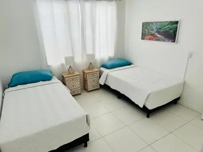 a room with two beds and two night stands at Casa Pura Vida in Puntarenas