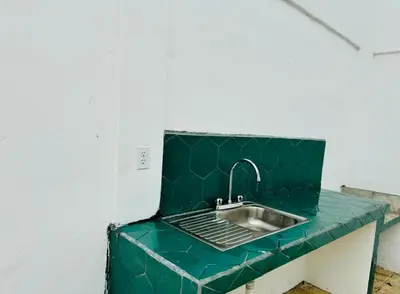 a green counter top with a sink in a room at Casa Pura Vida in Puntarenas