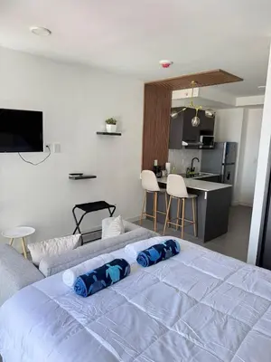 a bedroom with a white bed and a kitchen at Great View in Escalante! in San José