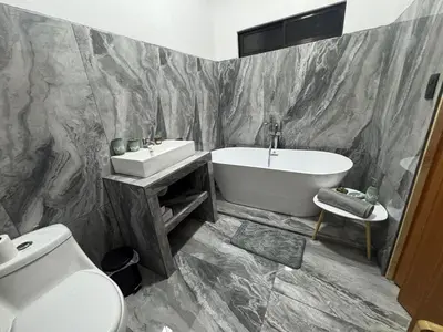 a bathroom with a tub and a sink and a toilet at Villa Tucán Fortuna in Fortuna