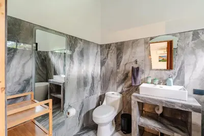 a bathroom with a toilet and a sink at Villa Tucán Fortuna in Fortuna