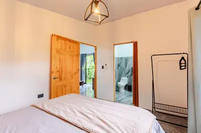 a bedroom with a bed and a door to a bathroom at Villa Tucán Fortuna in Fortuna