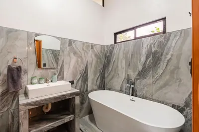 a bathroom with a white tub and a sink at Villa Tucán Fortuna in Fortuna