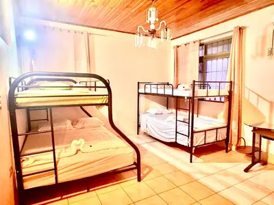 a room with two bunk beds and a table at Hostel La Perla in Puntarenas
