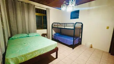 a bedroom with two bunk beds and a chandelier at Hostel La Perla in Puntarenas