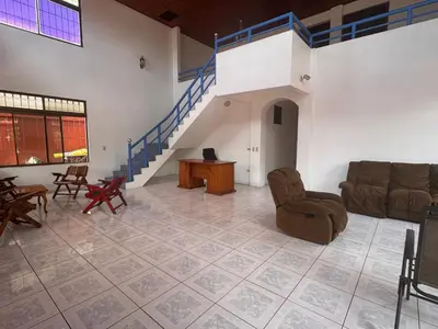 a living room with a couch and chairs and a staircase at Hostel La Perla in Puntarenas