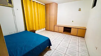 a room with a bed and a yellow curtain at Hostel La Perla in Puntarenas