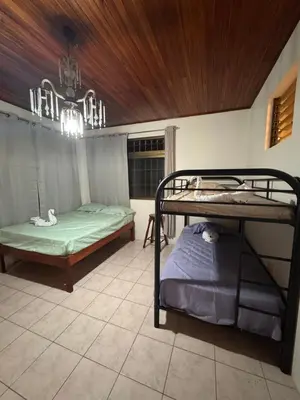 a room with two bunk beds and a window at Hostel La Perla in Puntarenas