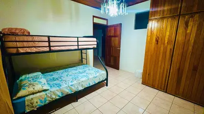 a bedroom with two bunk beds and a chandelier at Hostel la perla in Puntarenas