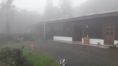 a foggy yard next to a house in the rain at Hotel Holístico Monteverde in Monteverde Costa Rica