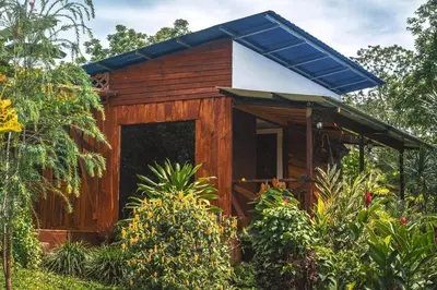 a small wooden house with a blue roof at Natural - cabin, 30 min Fortuna, wifi 200mb in San Pedro