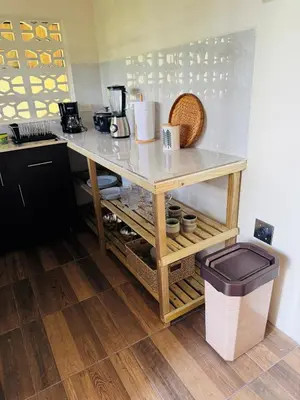 a kitchen with a counter with a table and a trash can at Casa De Daniel in Daniel Flores