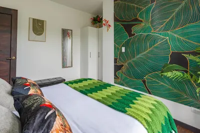 a bedroom with a bed with a painting on the wall at La Vista in Piedras