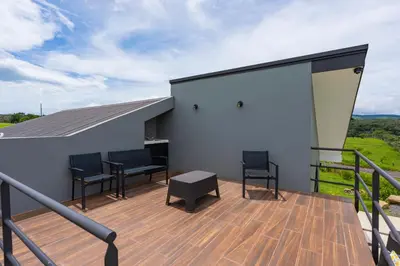 a balcony with two chairs and a table on a building at La Vista in Piedras