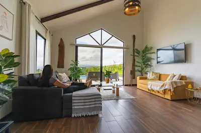 a woman sitting on a couch in a living room at La Vista in Piedras