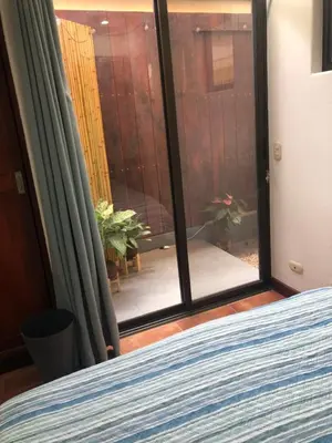 a bedroom with a sliding glass door with a view at Playa Grande, Las Baulas National Park BnB in Playa Grande
