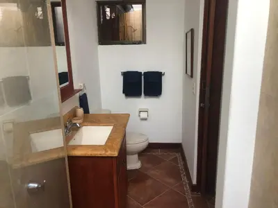 a bathroom with a toilet and a sink and a mirror at Playa Grande, Las Baulas National Park BnB in Playa Grande