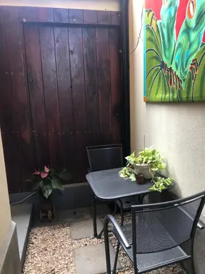 a patio with a table and chairs next to a wall at Playa Grande, Las Baulas National Park BnB in Playa Grande