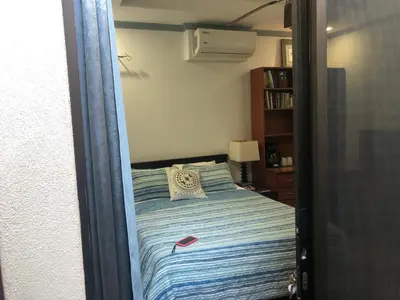 a bedroom with a bed with a blue and white striped sheets at Playa Grande, Las Baulas National Park BnB in Playa Grande