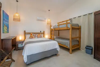 a bedroom with a bunk bed and a chair at Corozalito Turtle Inn in Nandayure