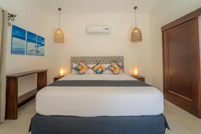 a bedroom with a bed with two lamps and two tables at Corozalito Turtle Inn in Nandayure