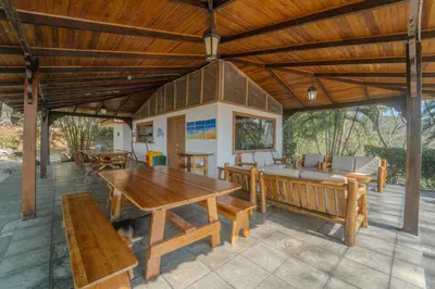 an outdoor patio with a wooden table and benches at Corozalito Turtle Inn in Nandayure