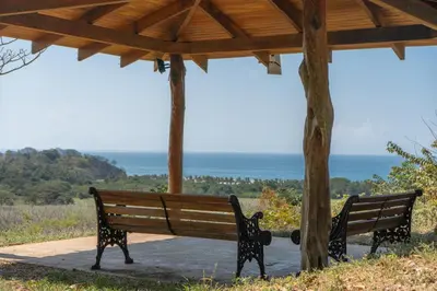two park benches sitting under a gazebo at Corozalito Turtle Inn in Nandayure