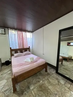 a bedroom with a bed and a mirror in it at Vacaciones en Tortuguero in Tortuguero