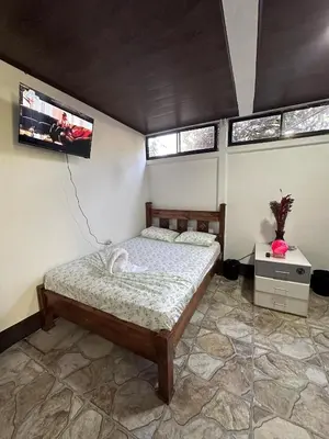 a bedroom with a bed and two windows at Vacaciones en Tortuguero in Tortuguero