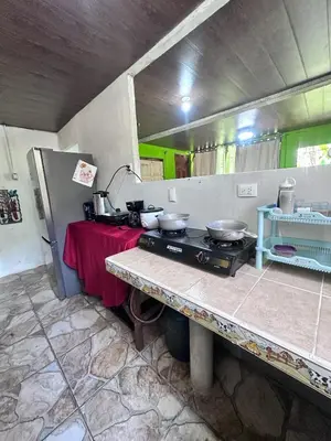 a kitchen with a stove and a table with pots and pans at Vacaciones en Tortuguero in Tortuguero