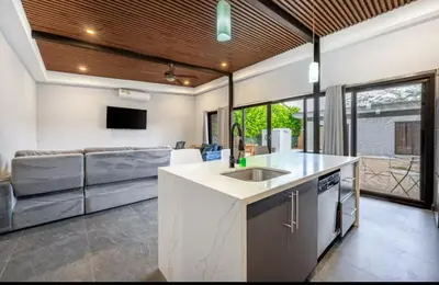 a kitchen with a sink and a living room at Villa Paradise in Guatemala