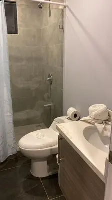 a bathroom with a toilet and a shower and a sink at Villa Paradise in Guatemala