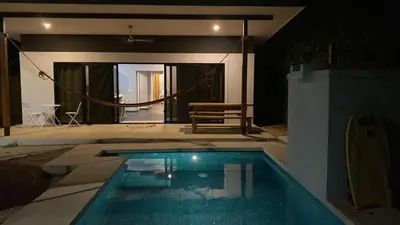 a swimming pool in front of a house at Villa Paradise in Guatemala