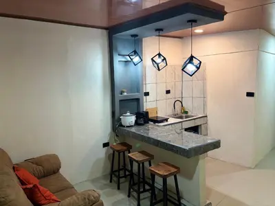 a kitchen with a sink and a counter with stools at Steps by Monteverde in Monteverde Costa Rica
