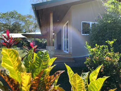 a house with a bunch of plants in front of it at Casa Heliconia - Gorgeous Garden Home in Delicias in Puntarenas