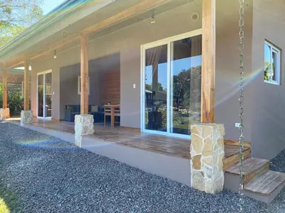 a home with a porch with glass doors and a patio at Casa Heliconia - Gorgeous Garden Home in Delicias in Puntarenas