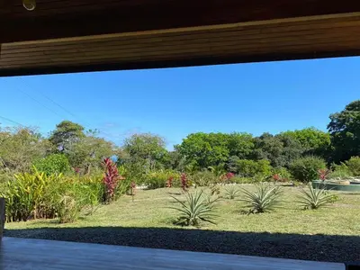 a view of a garden through a window at Casa Heliconia - Gorgeous Garden Home in Delicias in Puntarenas