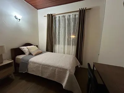 a small bedroom with a bed and a window at Vargas Lodge, Costa Rica in San Vicente