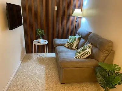 a living room with a brown couch and a table at Vargas Lodge, Costa Rica in San Vicente