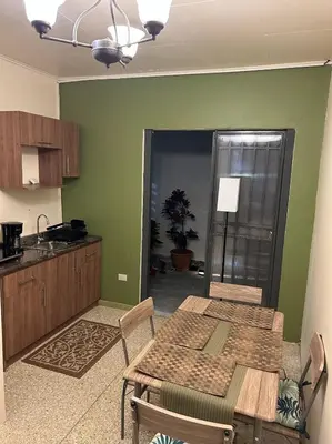 a dining room with a table and a kitchen at Vargas Lodge, Costa Rica in San Vicente
