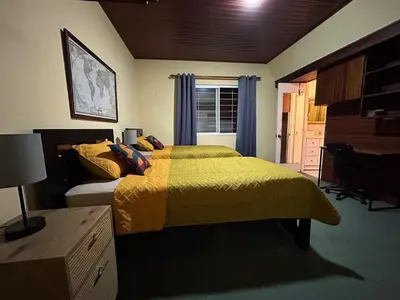 a bedroom with a bed and a desk and a window at Vargas Lodge, Costa Rica in San Vicente