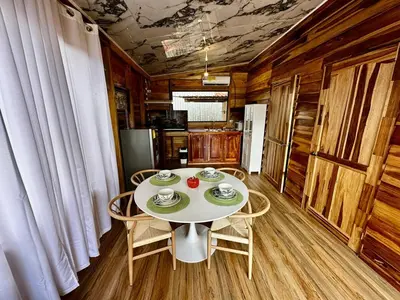 a dining room with a white table and chairs at Tribu Bungalow 1 Modern and Centrally Located in Fortuna