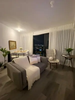 a living room with a couch and a window at Apartamento en Barrio Escalante in San José