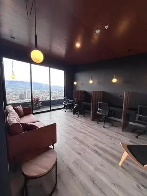 a living room with a couch and chairs and windows at Apartamento en Barrio Escalante in San José