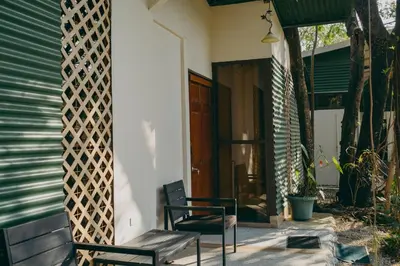 a porch with a bench and a door and a house at Chilamate Rainforest Beach Retreat in Nosara