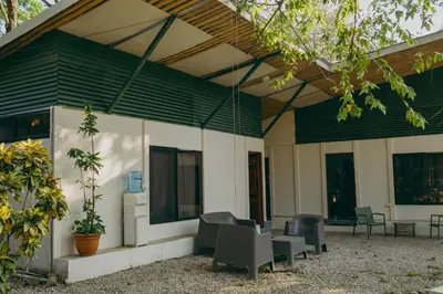a building with chairs and tables and windows at Chilamate Rainforest Beach Retreat in Nosara